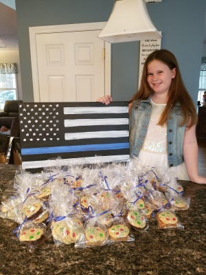 Caoimhe Assad with cookies she baked to raise funds. A nine-year-old Massachusetts girl donated St. Michael medals to all MIPD officers to help keep them safe.
