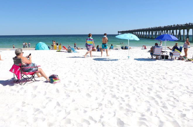 People enjoy the sun at Navarre Beach as the Santa Rosa County beaches reopen during the coronavirus shutdown in Navarre on Friday, May 1, 2020.