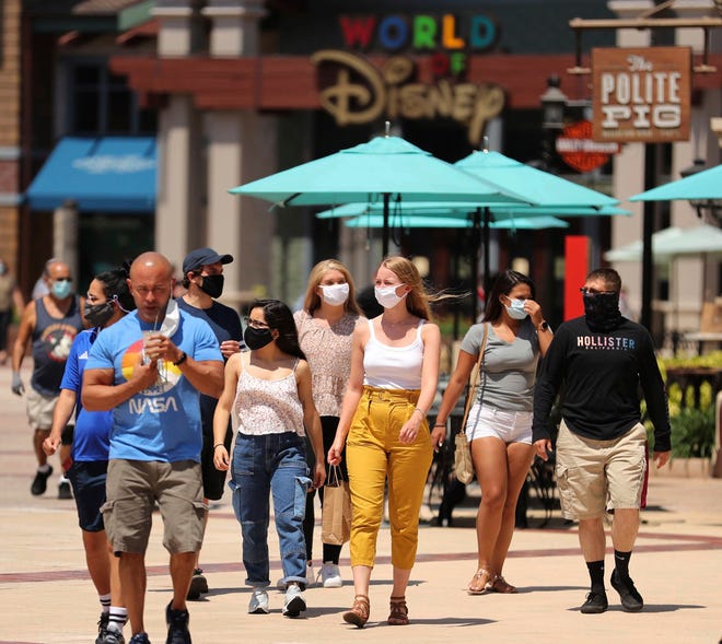 Guests stroll at Disney Springs in Orlando, Florida, on May 20, 2020. Disney Springs, along with other Florida attractions, had been closed due to the coronavirus pandemic.
