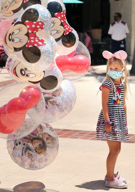 A girl gazes at Mickey Mouse balloons at Disney Springs in Orlando on May 20, 2020.