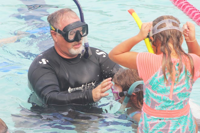 John Blake of ScubaMarco helps a camper become used to wearing the appropriate gear.