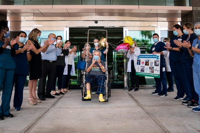 Richard Czekanski, center, is wheeled out of the building as doctors, nurses and hospital staff clap at Physicians Regional Medical Center Pine Ridge in Naples on Thursday, June 11, 2020. Czekanski, 85, was released on his birthday after spending more than ten weeks at the hospital recovering from COVID-19.