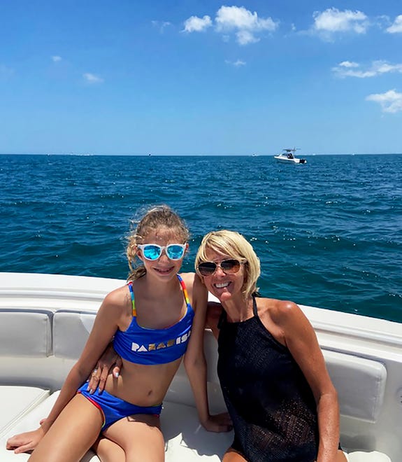 Sofia Wilson and her mother Kim Wilson on a boat off the Florida coast in May. Two young girls from 1,000 miles apart were connected when a message in bottle sent by one was found by the other, prompting communication and dreams.