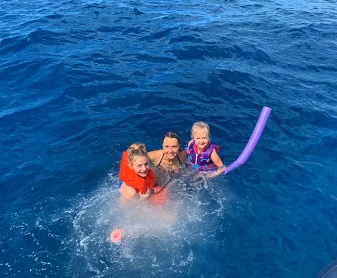 Sarah Wilson, left, swimming with family members in Florida. Two young girls from 1,000 miles apart were connected when a message in bottle sent by one was found by the other, prompting communication and dreams.