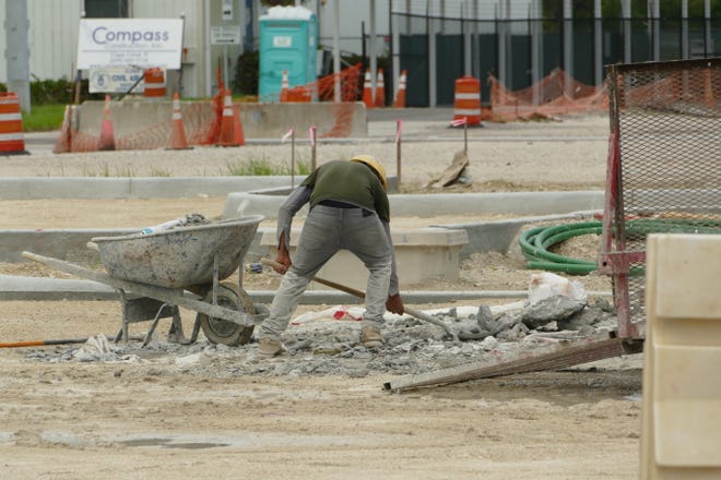 Construction worker holds a shovel at Marco Island Executive Airport on July 20, 2020.