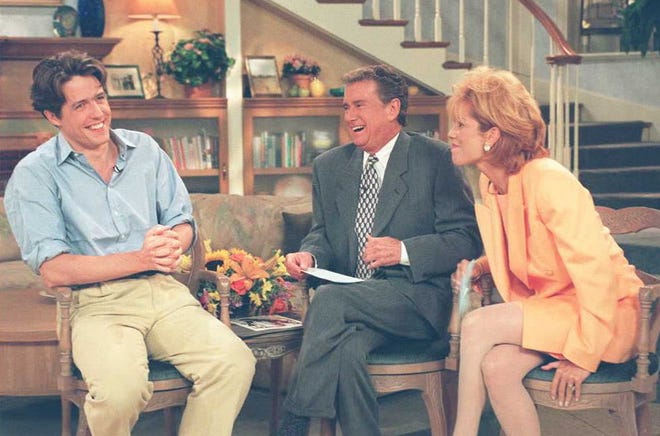Hugh Grant, left, is interviewed by Regis Philbin, center, and Kathie Lee Gifford on the set of "Live! With Regis and Kathie Lee" on July 14, 1995.