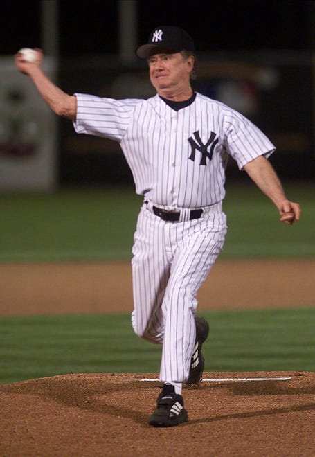 "Who Wants to Be A Millionaire?" host Regis Philbin tosses out the first pitch of the New York Yankees and Minnesota Twins game on March 7, 2000, at Legends Field in Tampa, Florida.