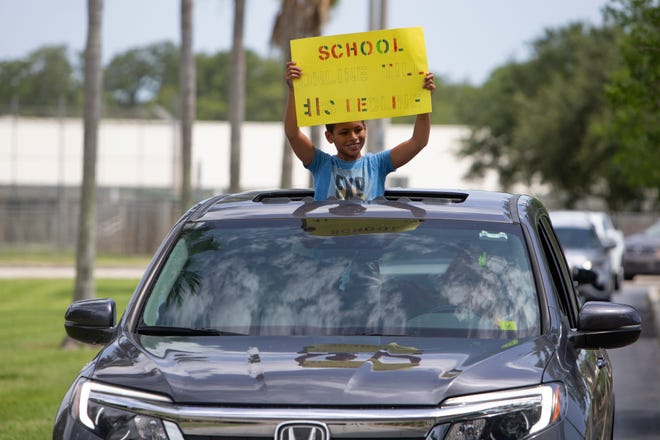 Andre Carrington and his step mother Renee Carrington, a teacher at Beacon  High School, drive past the Collier County Public Schools Dr. Martin Luther King, Jr. Administrative Center offices on Monday, July 27, 2020, to demonstrate against the upcoming plans to reopen schools for the upcoming school year.