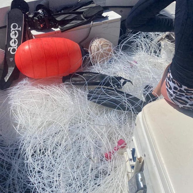 Longline fishing gear is mixed in with swim fins and dive gear as a shark diving charter returns to Jupiter Inlet.