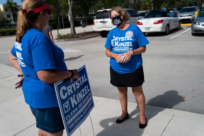 Collier County Clerk of Courts incumbent Crystal Kinzel, right, talks to volunteer Robin Sheley, left, during primary election day outside of precinct 251 at the Collier County library headquarters in Naples on Tuesday, August 18, 2020.