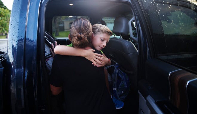 Maxwell Claypool,7, hugs his mother, Beth Collette goodbye as he heads off to Tanglewood Elementary for the first day of school on Monday, August 31, 2020. He is starting the second grade and is will be taking face to face classes.