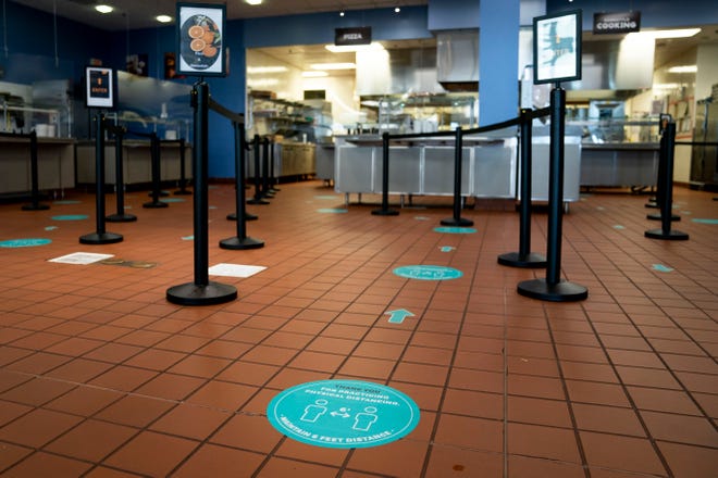 Markers on the floor encourage social distancing as students wait in line for food in the dining hall at Ave Maria University on Thursday, September 17, 2020.
