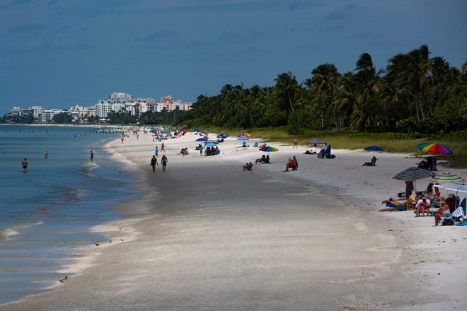 Visitors relax along along the shore of Naples beach, Wednesday, Sept. 23, 2020.