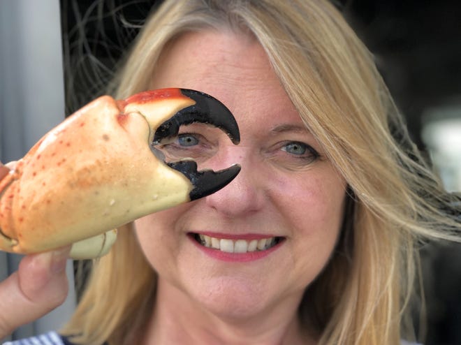 Karen Bell, owner of Star Fish Company and A.P. Bell Fish Co. in Cortez, poses with a stone crab claw frozen from the previous season.