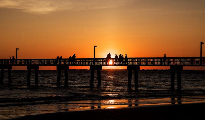 Visitors enjoy a sunset on the Fort Myers Beach pier on Monday, October 12, 2020.