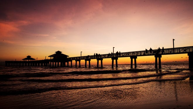 Visitors enjoy a sunset on the Fort Myers Beach pier on Monday, October 12, 2020.