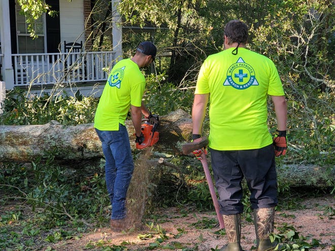 In the aftermath of Hurricane Delta, Marco Patriots and first responders cut downed trees in Abbeville, Louisiana on Oct. 10, 2020.