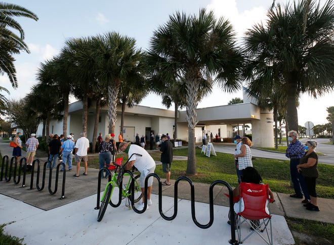 Voters line up City Island in Daytona Beach to cast their vote as early voting begins, Monday, Oct. 19, 2020.