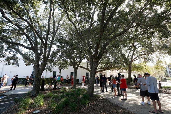 Voters line up at Ormond Beach Regional Library to cast their vote as early voting begins, Monday, Oct. 19, 2020.