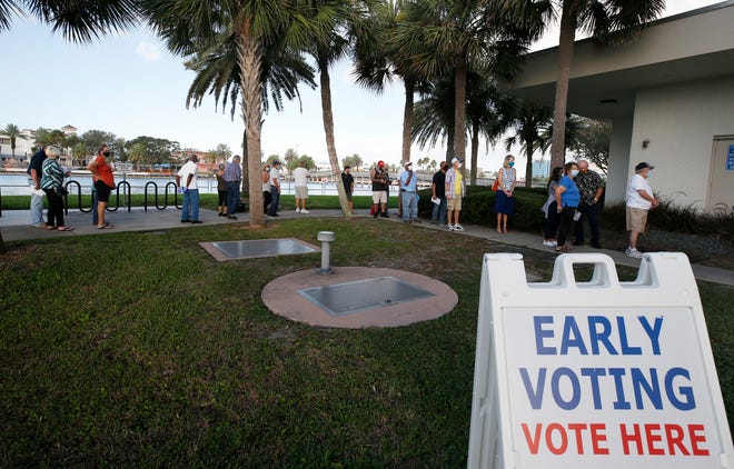 Voters line up City Island in Daytona Beach to cast their vote as early voting begins, Monday, Oct. 19, 2020.