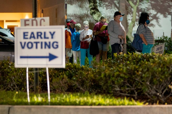 Voters wait in line to cast their ballots at the during the first day of early voting at the Palm Gardens Branch Library in Palm Beach Gardens, Florida on Oct. 19, 2020. See more photos .