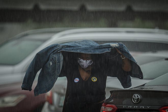 A woman walks to her car after voting at Wells Recreation Community Center during morning rains in Riviera Beach, Fla., on Monday, October 19, 2020.
