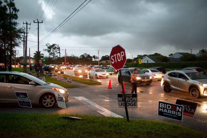 Voters brave heavy traffic and rain as they line up to vote at the Lantana Road Branch Library during the first day of in-person early voting in Palm Beach County at Monday October 19, 2020 in Lake Worth.  [MEGHAN MCCARTHY/palmbeachpost.com]