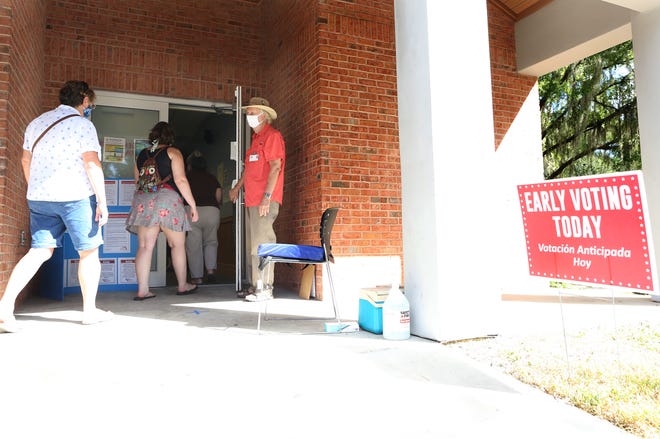 Residents walk into the earring voting location at the Millhopper Branch of the Alachua County Library to vote in the 2020 Presidential Election in Gainesville Fla., Oct. 19, 2020. Alachua County has six early voting locations that are open daily 9am to 6pm.