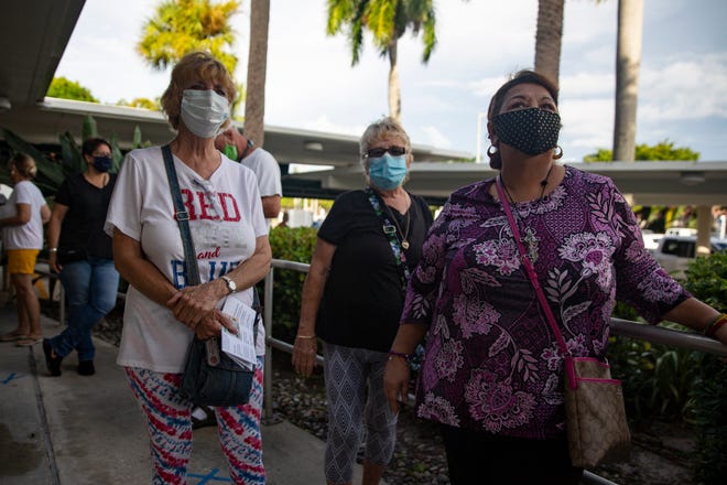 Naples residents Connie Bertrand, left, Sandy Corzine and Yolanda Herrera wait in line for early voting, Monday, Oct. 19, 2020, at the Collier County Government Center in East Naples.