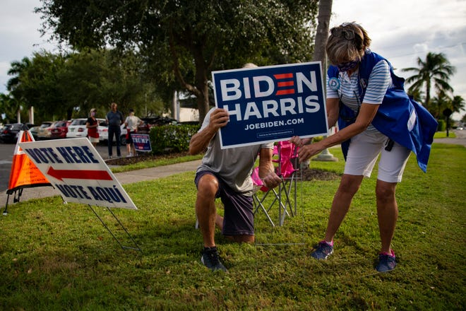 Democratic Party volunteers put up a Biden Harris sign as they campaign outside the Norris Center in Naples on Monday, Oct. 19, 2020.