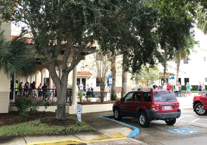 A line of people had formed outside Sebastian City Hall by noon Monday, Oct. 19, 2020, with people spilling out into the courtyard on the first day of early voting, despite brief rain showers.