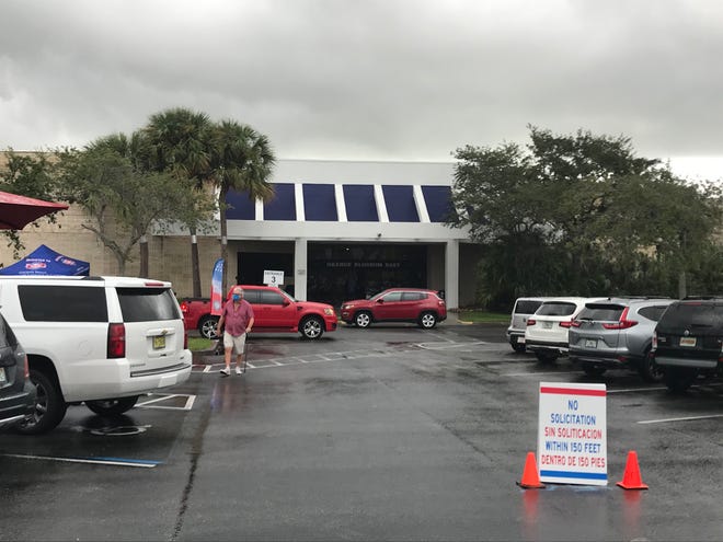 Voters dodge raindrops to get into the Supervisor of Elections Office in the Orange Blossom Business Center Monday, Oct. 19, 2020, for early voting in Fort Pierce.