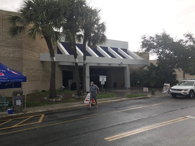 Voters dodge raindrops to get into the Supervisor of Elections Office in the Orange Blossom Business Center Monday, Oct. 19, 2020, for early voting in Fort Pierce.