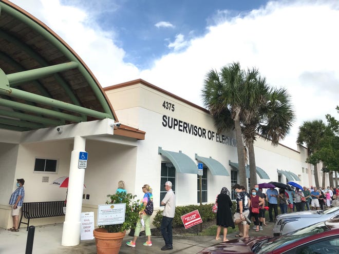 Dozens of people wait to get into the Indian River County Supervisor of Elections office on the first day of early voting Monday, Oct. 19, 2020, in Vero Beach, Fla.