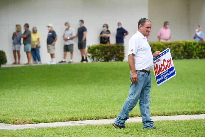 Craig MacCoy, running for Indian River County Mosquito Control District Seat 1, walks the perimeter of the Indian River County Library on Monday, Oct. 19, 2020, on the first day of early voting in Vero Beach.