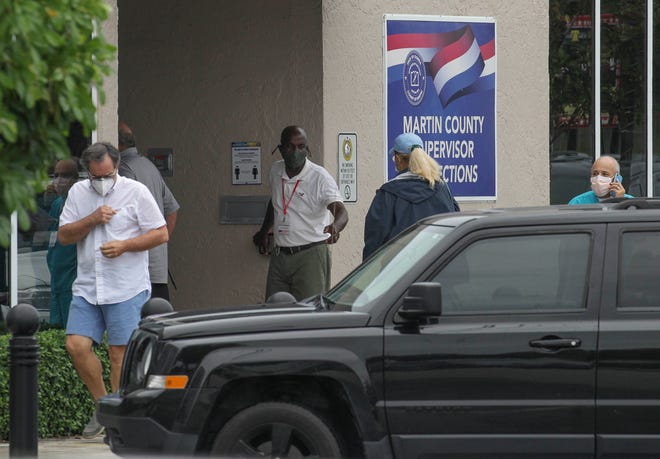 A small crowd waits outside the Martin County Supervisor of Elections office as local voters head to the polls to cast their ballot on the first day of early voting in Florida on Monday, Oct. 19, 2020, in Stuart. By afternoon, some of the long lines begin to thin to a steady flow after rain showers passed through the County.