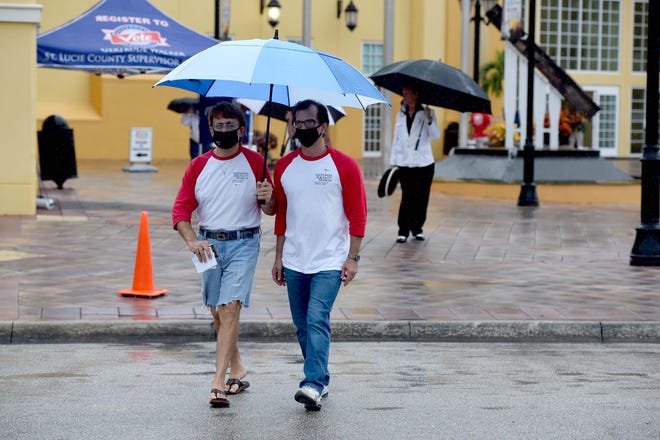 David (left) and Stuart Mohr, a couple from Port St. Lucie, Leave the MidFlorida Event Center after casting their ballot on Monday, Oct. 19, 2020, in Port St. Lucie. “It’s important to vote because one way or another the country’s going to speak and decide who’s going to run the show,” David Mohr said. “This is America we are here for equality. Everybody hurting on both sides, come out and let us know what you think.” They waited 90 minutes from the time they arrived until they voted, due to the rain outside.