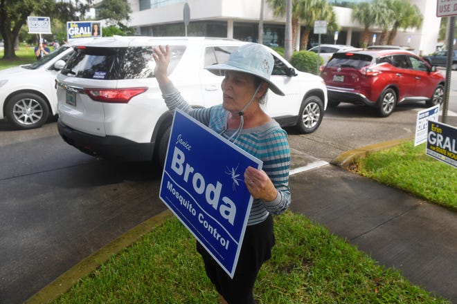Janice Broda, running for Indian River County Mosquito Control District Seat 1, waves to motorists as they file into the parking lot of the Indian River County Library on Monday, Oct. 19, 2020, on the first day of early voting for the general election in Vero Beach. "I got here about 8:15 a.m. a steady stream of people coming and going all morning," Broda said.
