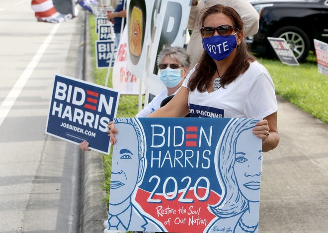 Brenda Brinkley from Lake Worth shows her support for Biden as Voters await the arrival of President Trump, outside of the early voting polling station located at The Palm Beach County Library, 3650 Summit Blvd. West Palm Beach.