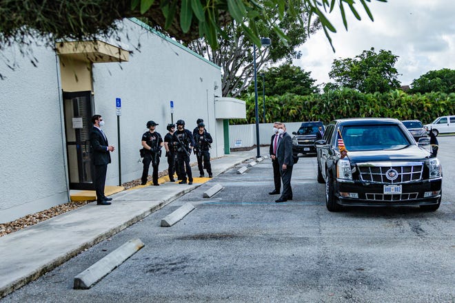 Secret Service agents wait outside the on Summit Blvd. next the the Presidential limousine, also called “The Beast”. President Donald J. Trump cast an early ballot for the 2020 presidential election at the  library on Summit Blvd. in West Palm Beach, Saturday October 22, 2020.