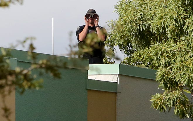 A sniper on the roof of The Palm Beach County Library keeps a watchful eye on the crowd as the await the arrival of President Trump, outside of the early voting polling station located at The Palm Beach County Library, 3650 Summit Blvd. West Palm Beach.