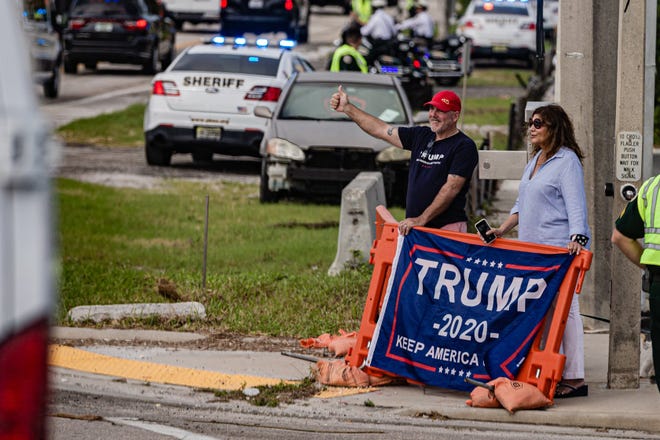 Supporters wave to the Presidential motorcade as it travels west along Southern Blvd. as it heads to the main branch of the Palm Beach County library on Summit Blvd. in West Palm Beach, Saturday, October 24, 2020. President Donald J. Trump cast his ballot for the 2020 presidential election at the library this morning.