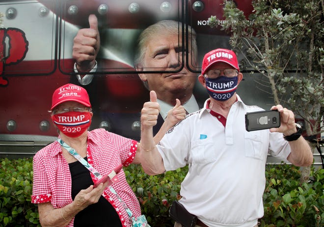 Trump supporters Karen & Ledford Cade, from Michigan, give a thumbs up to President Trump and his motorcade as they pass by the the crowd on Summit Blvd in West Pam Beach after the president cast his vote at the early polling station.
