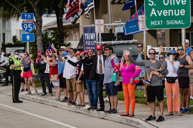 Supporters wave to the Presidential motorcade as it travels west along Southern Blvd. as it heads to the main branch of the Palm Beach County library on Summit Blvd. in West Palm Beach, Saturday, October 24, 2020. President Donald J. Trump cast his ballot for the 2020 presidential election at the library this morning.