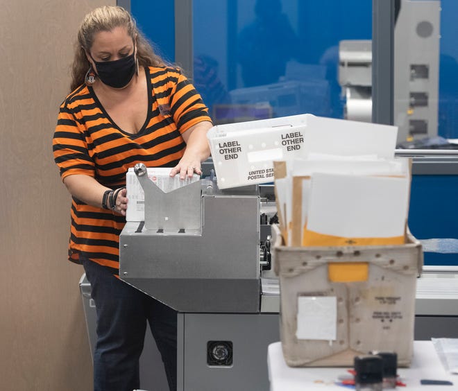 Brandi Ziglar, an Escambia County Supervisor of Election staff member, works to open ballots cast during the early voting process during a meeting of the Canvassing Board on Friday, Oct. 30, 2020. See more photos .