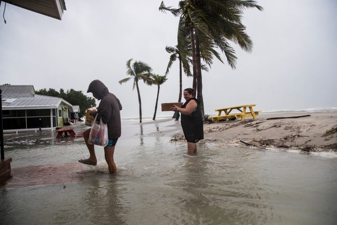 Michelle Albert and Debbie Schunk bring supplies into a cottage they are staying at at the Castaways Beach Bay Cottages on Sanibel Island near Blind Pass. The outer bands of Hurricane Eta lash the coast on Wednesday, November 11, 2020.