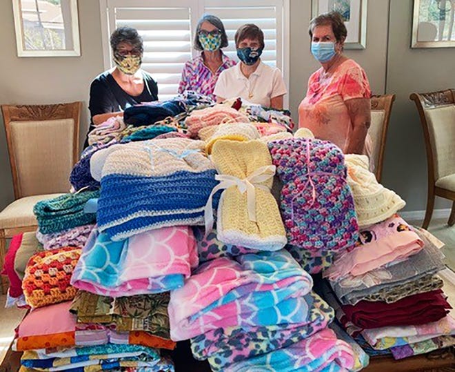 Marco Island Woman’s Club Stitch Makers Aren Alter, Roz Sorber, Catherine Thomas and Donna O’Shea folded and tied bows on the 121 blankets made by club members over the summer.
