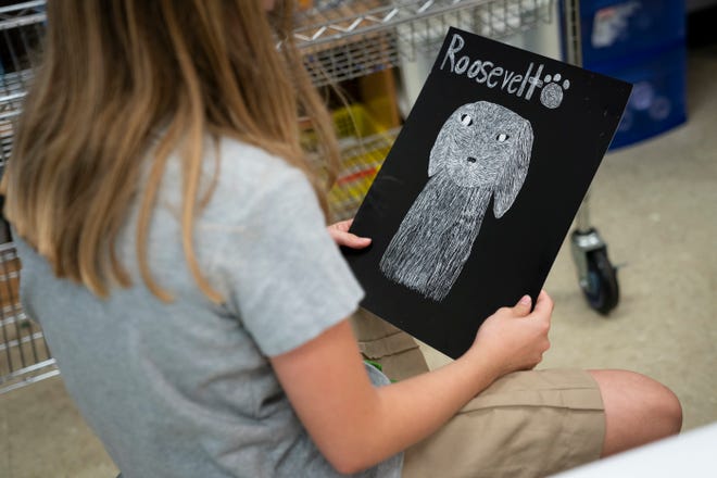 Amelia Delate holds her scratch art portrait of Roosevelt the dog at The Village School of Naples on Monday, January 25, 2021.