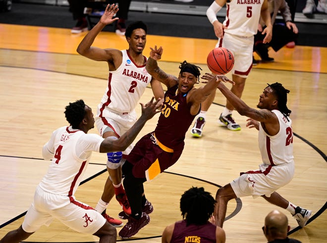 First round:  Iona Gaels guard Isaiah Ross passes the ball away from Alabama Crimson Tide defenders during the first round of the 2021 NCAA Tournament at Hinkle Fieldhouse.