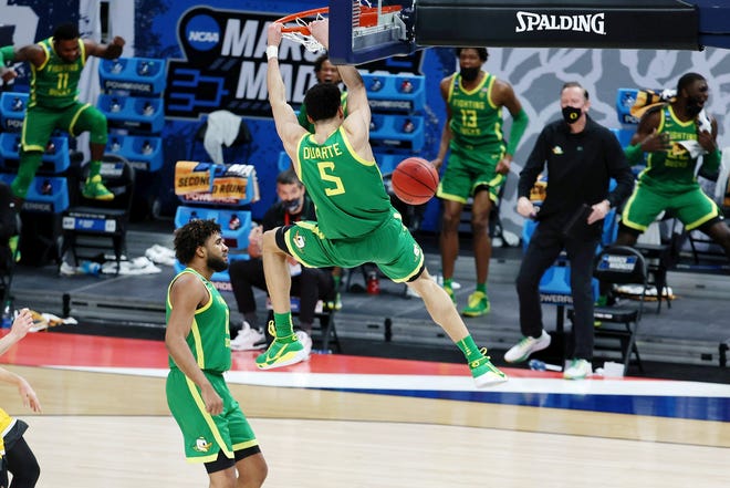 Second round: Oregon ' s Chris Duarte (5) hangs on the rim after dunking against Iowa. The Ducks routed the No. 2 seed Hawkeyes to move into the Sweet 16.
